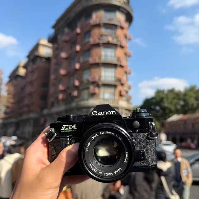 A Canon AE-1 Program held up in front of Wukang Mansion in Shanghai on a clear day