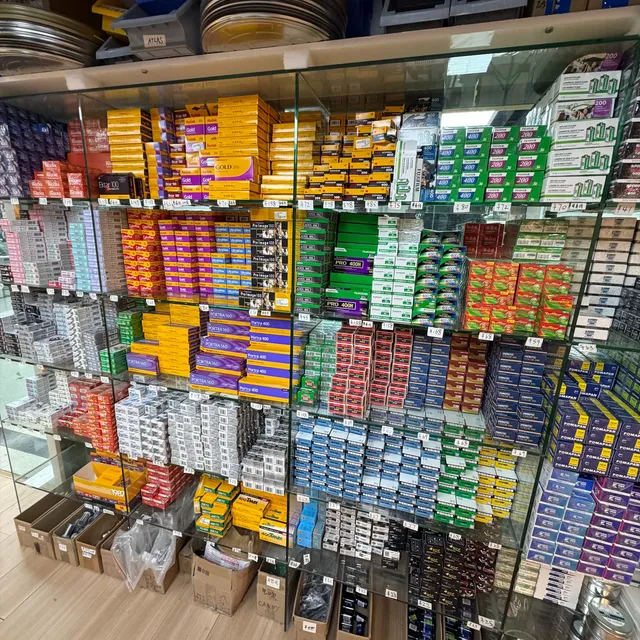 Glass shelves at a Shanghai film shop packed with Kodak, Fuji and Foma boxes, price tags in yuan